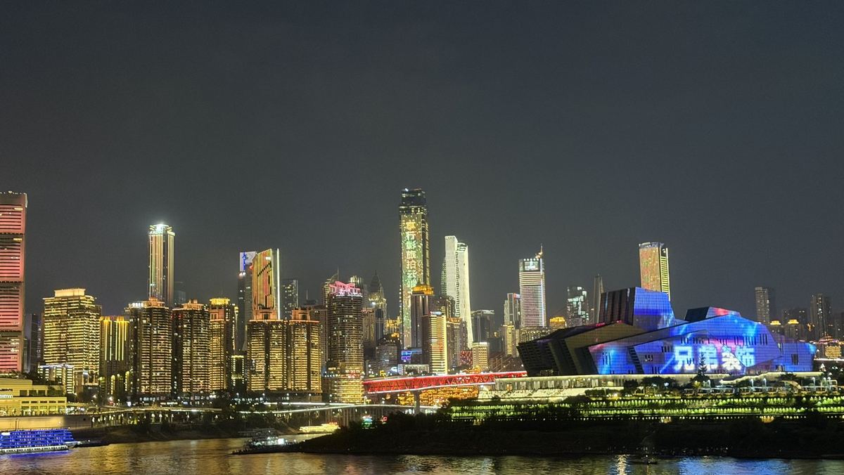 Chongqing skyline at night with the Grand Theatre lit blue on the riverbank