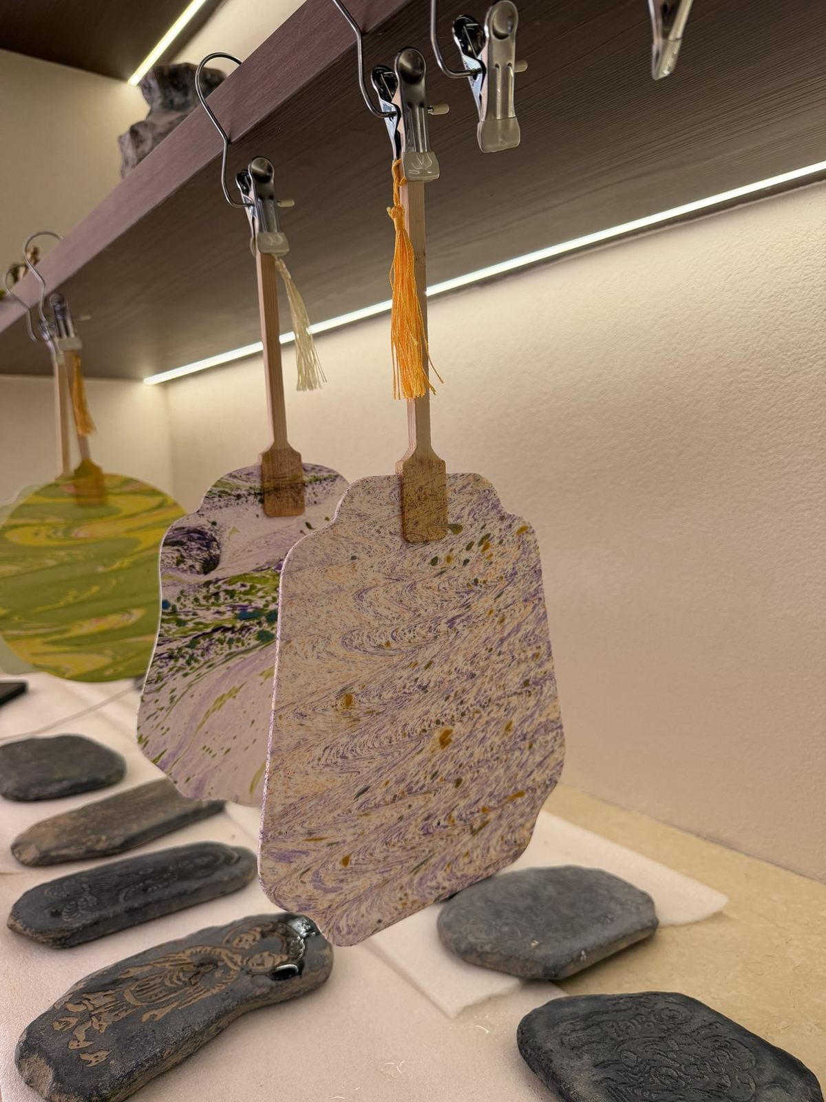 Hand painted paper fans drying above stone rubbings at the Boman Oasis Resort, Dunhuang