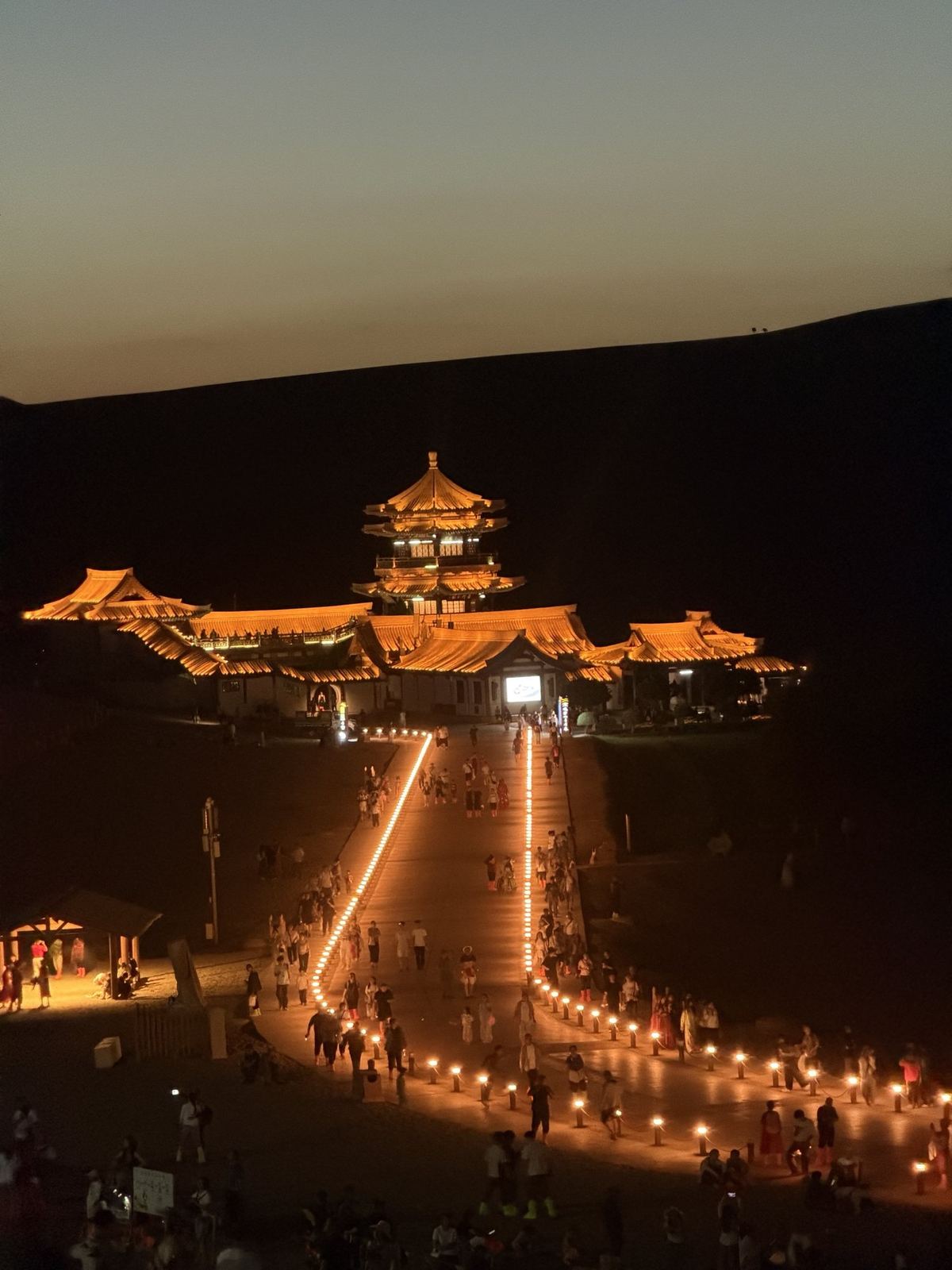 The Crescent Lake pavilion and lantern path lit up at night, Dunhuang
