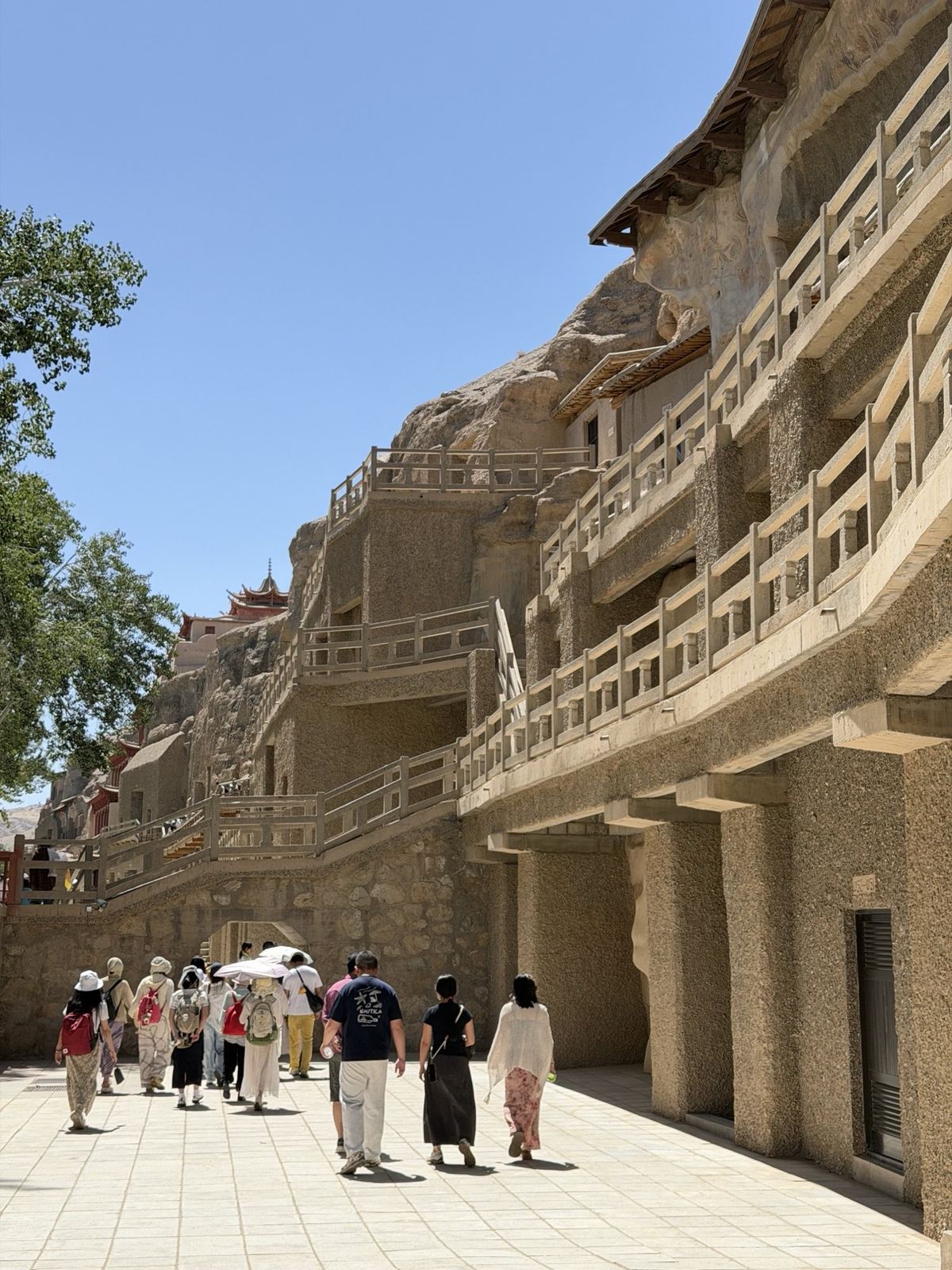 Visitors walking along the cliff face of the Mogao Caves, Dunhuang