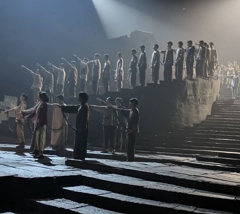 Chained prisoners on stage stairs in the Chongqing 1949 show