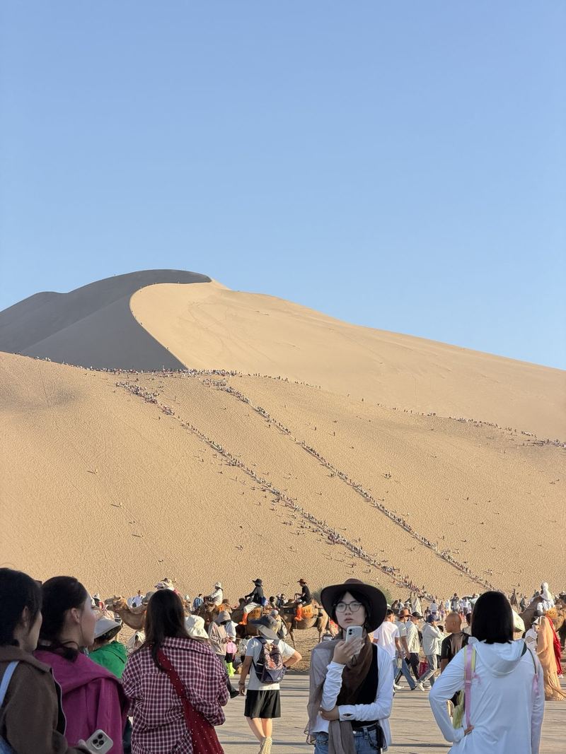 Crowds and camels at the foot of the Mingsha Shan dunes, Dunhuang