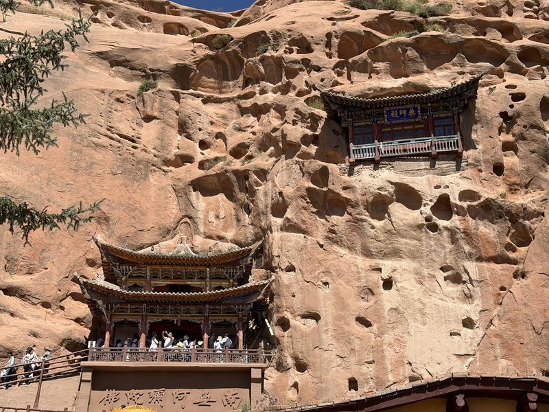 Temple halls built into the honeycombed sandstone cliff at Mati