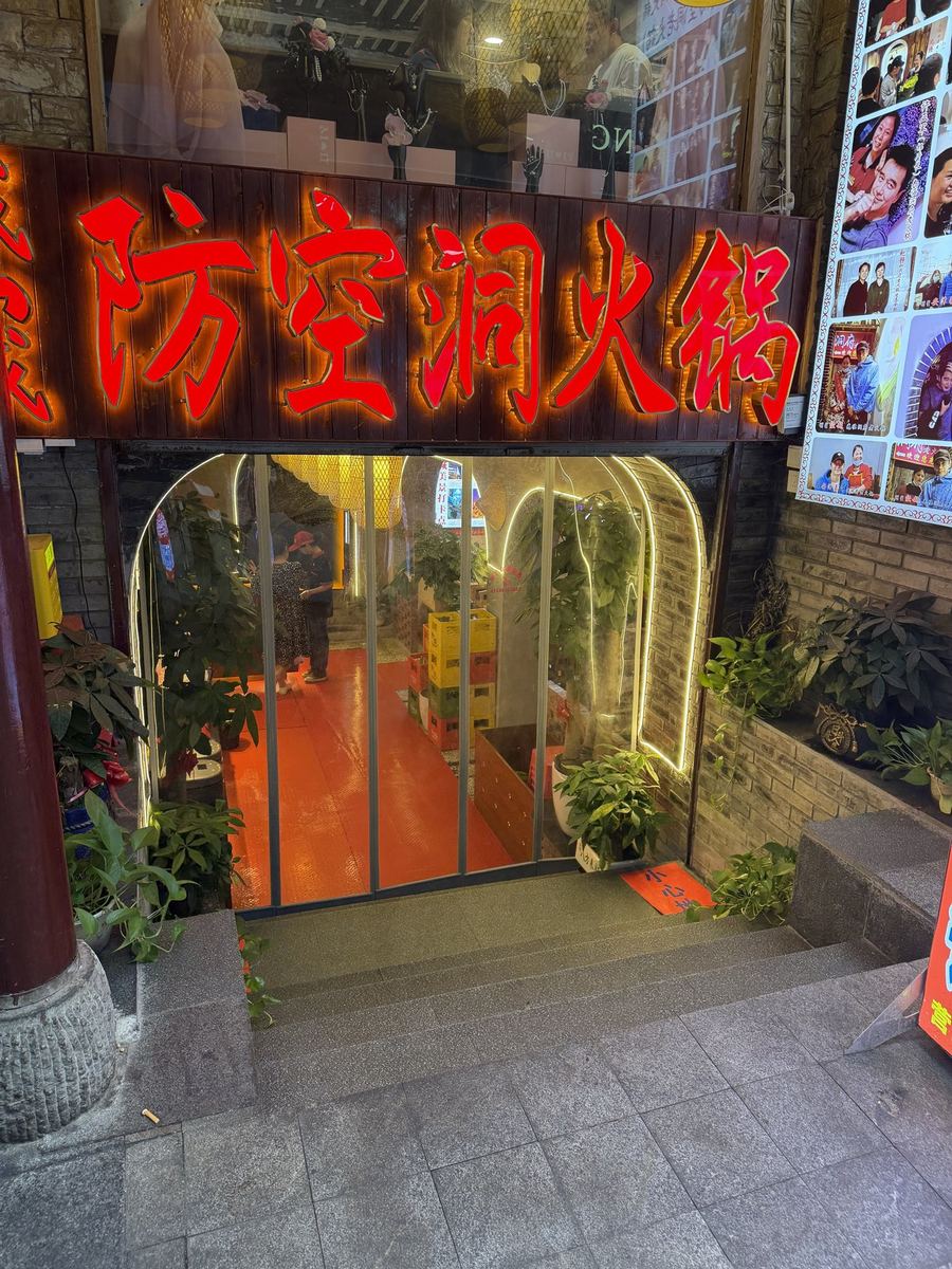 Red neon sign at the entrance of an air-raid shelter hotpot restaurant in Chongqing