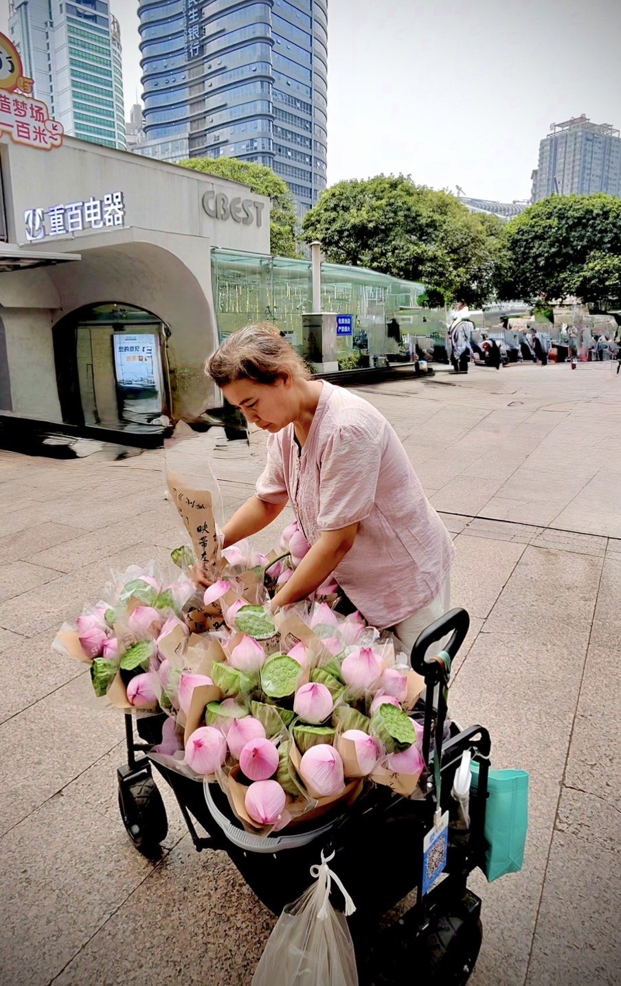 A woman selling lotus flowers from a cart in central Chongqing