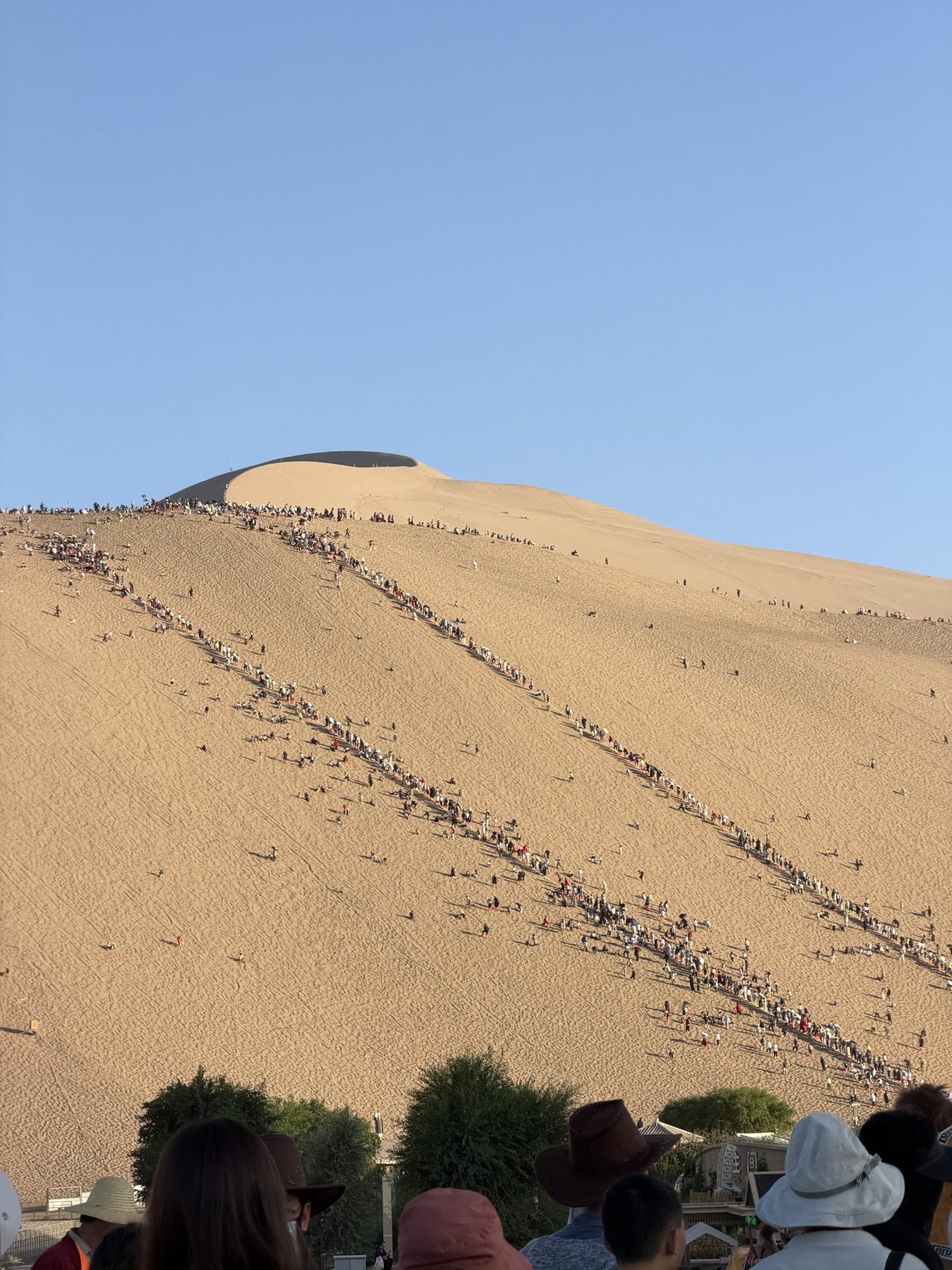 Lines of visitors climbing the Mingsha Shan dunes at sunset, Dunhuang
