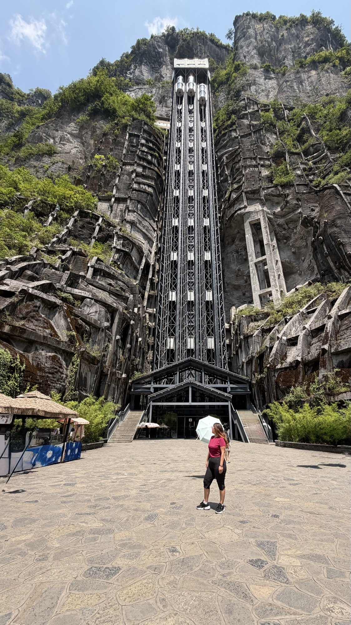Linda in front of the giant glass lift built against the cliff in Wulong
