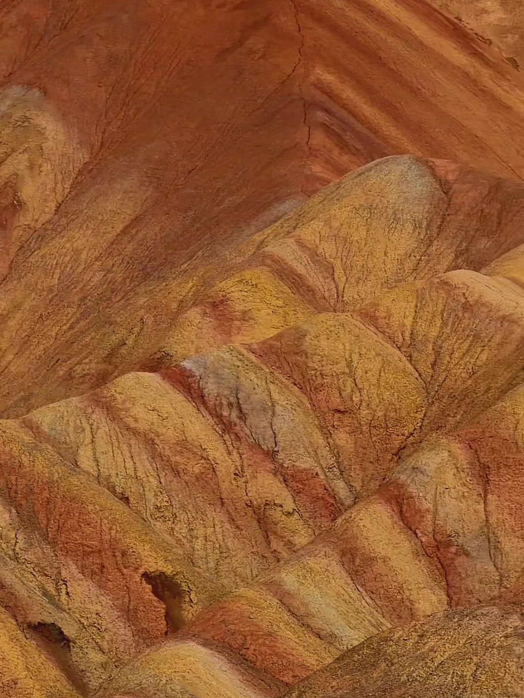 Close up of red, yellow and cream striped ridges in the Zhangye Danxia Rainbow Mountains